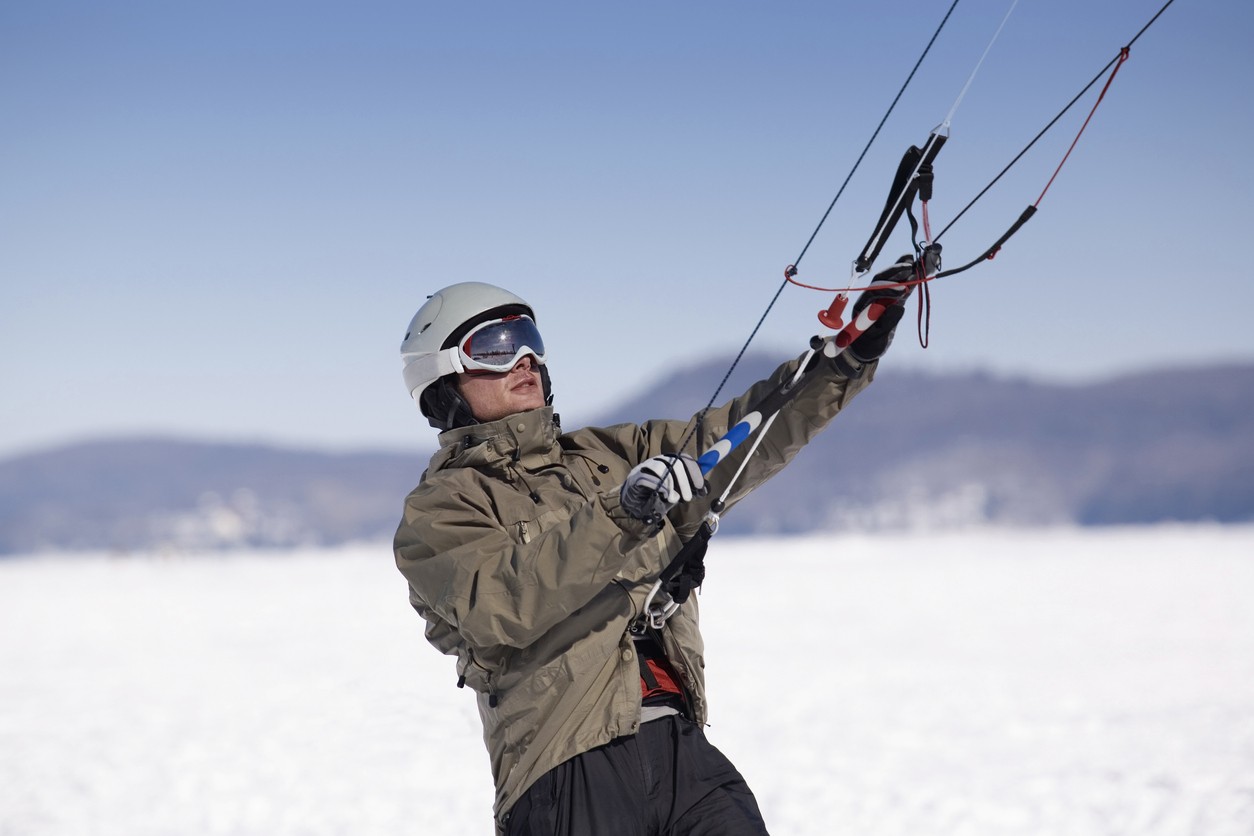 Snøkiting i Valdres med kite og snowboard i et snødekt fjellandskap.